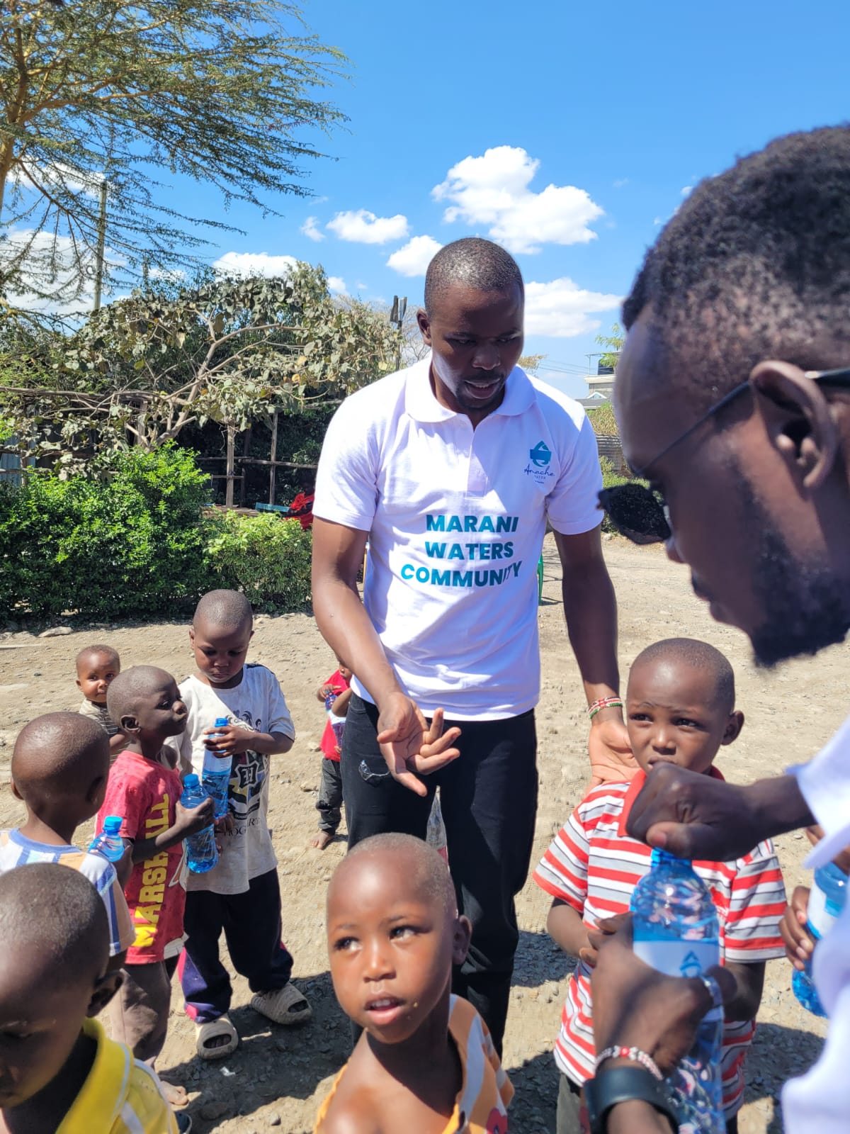 Children holding bottled water alongside Marani Waters volunteers